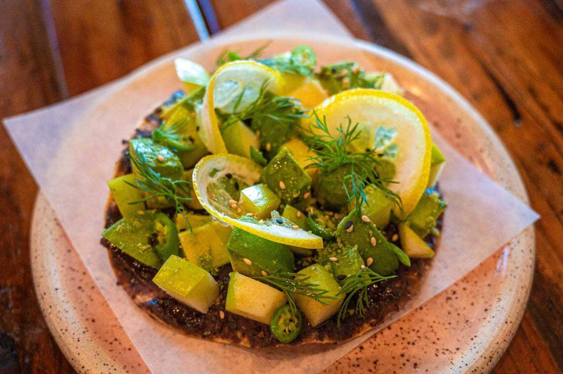 The Avocado Slayer, a tostada topped with chilled black bean puree, avocado, green apples and serrano peppers is available at StreetZlan in Elk Grove on Wednesday. The dish is garnished with fresh dill, lemon slices, crushed wasabi peas and sesame seeds.