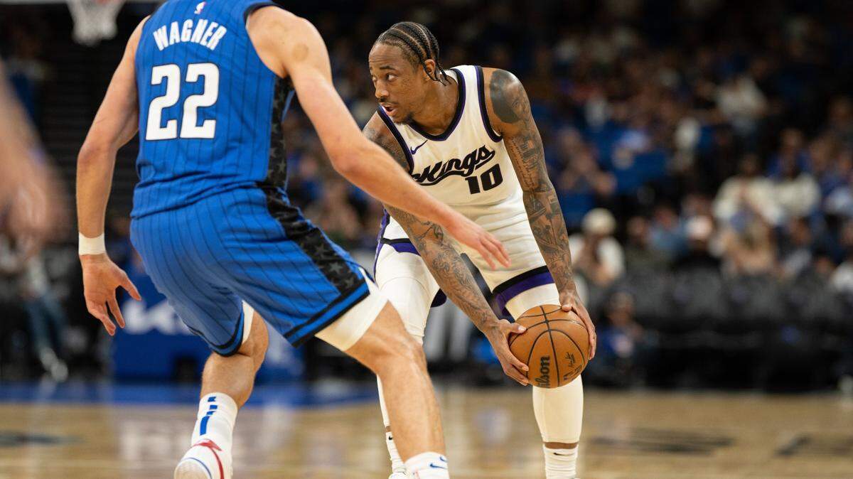 Mar 29, 2025; Orlando, Florida, USA; Sacramento Kings guard/forward DeMar DeRozan (10) dribbles the ball against Orlando Magic forward Franz Wagner (22) in the first quarter at Kia Center. Mandatory Credit: Jeremy Reper-Imagn Images