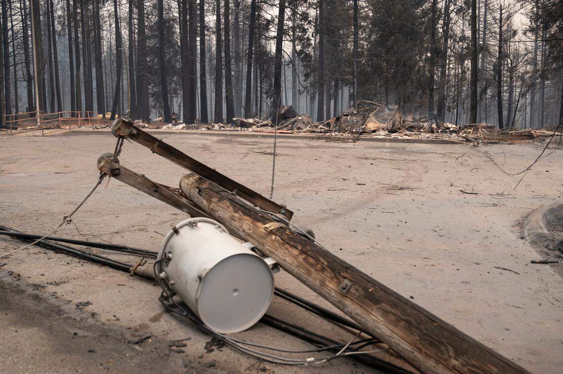 Power lines lay on the ground in front of the burned U.S. post office on Sciaroni Road after the Caldor Fire burned through Grizzly Flats on Tuesday, Aug. 17, 2021.