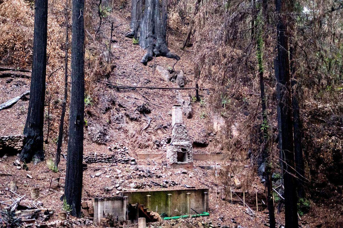 A chimney stands beneath a hillside at a residence scorched by the CZU Lightning Complex Fire in Santa Cruz County, Calif., on Tuesday, Jan. 26, 2021. Residents of the Santa Cruz Mountains are under evacuation warnings as heavy rains threaten to cause mudslides in areas burned during last summer’s wildfires.
