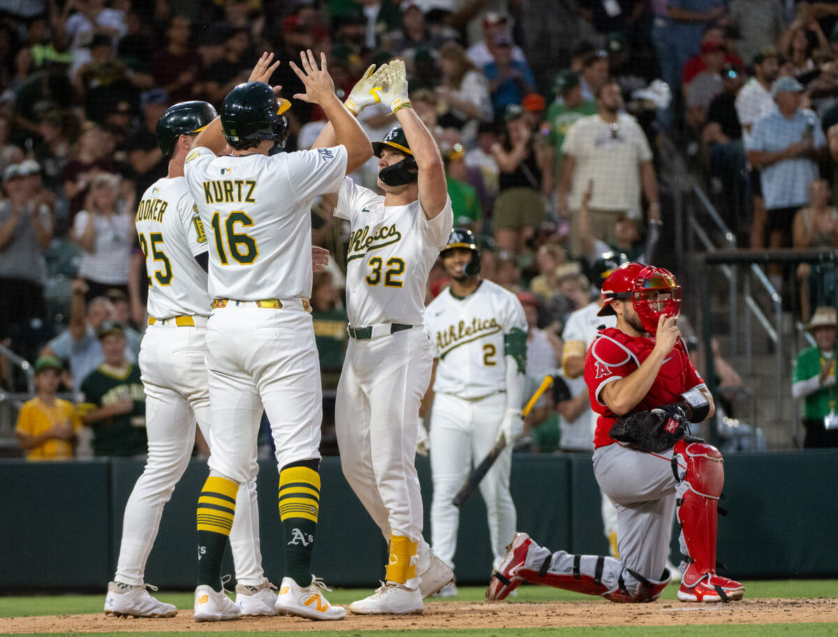Athletics outfielder Colby Thomas (32) is congratulated at the plate by Nick Kurtz (16) and Brent Rooker (25) after his three-run home run in the third inning against Los Angeles Angels pitcher Yusei Kikuchi during a game at Sutter Health Park on Friday in West Sacramento.