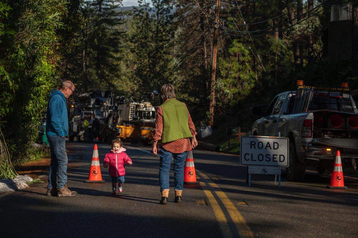 Barry Ummel, a la izquierda, su esposa Kim y su nieta Darcy, de dos años, observan cómo un equipo reemplaza un poste de electricidad en Norlene Way en Alta Sierra el jueves. Los Ummel, que se quedaron sin electricidad el 27 de diciembre, son uno de los casi 7,800 residentes del Condado Nevada que han estado sin electricidad desde las fuertes tormentas de nieve de diciembre.