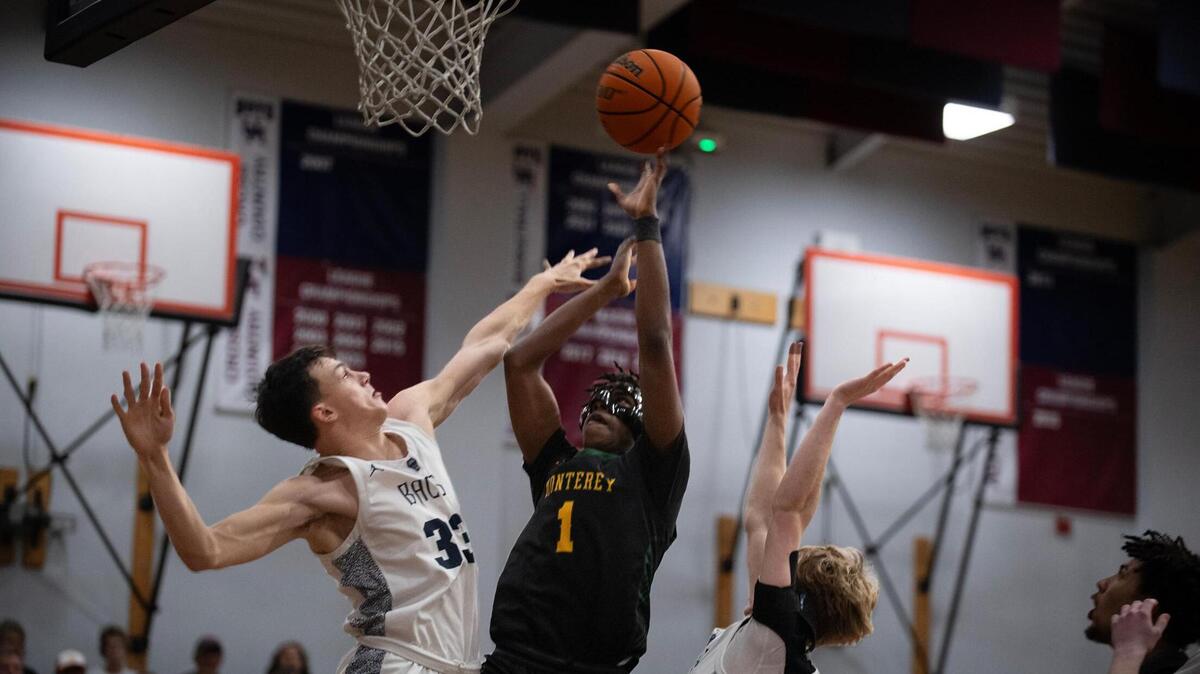 The Monterey Dores’ Suheib Ibrahim (1) scores over the Union Mine Diamondbacks’ Isaac Zmerzlikar (33) and Nate Sweet (23) in the first half of the Division lV Northern California boys basketball regional championship game at Union Mine High School in El Dorado on Tuesday.