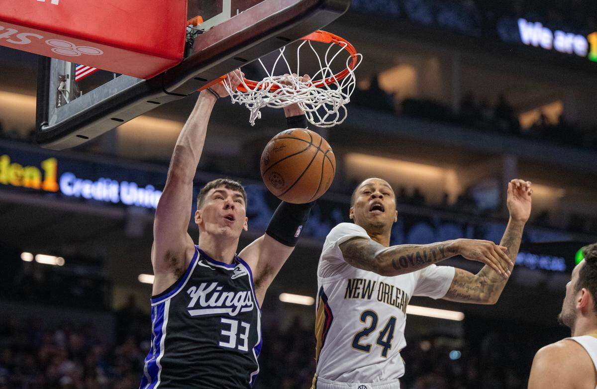 Sacramento Kings forward Jake LaRavia (33) scores past New Orleans Pelicans guard Jordan Hawkins (24) in the first half on Saturday, Feb. 8, 2025 at Golden 1 Center.