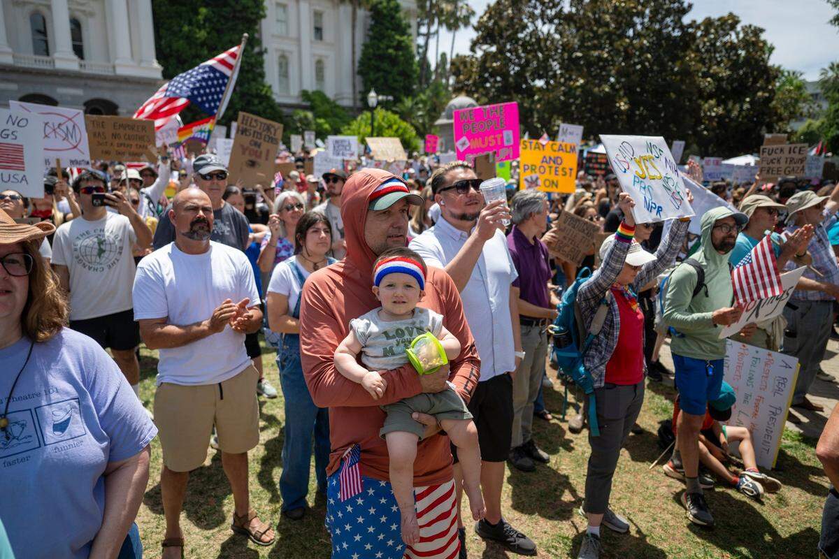 Viggo, 1, and Isaac Lassiter stand in front of the state Capitol during the “No Kings” protest against the Trump administration in downtown Sacramento on Saturday.