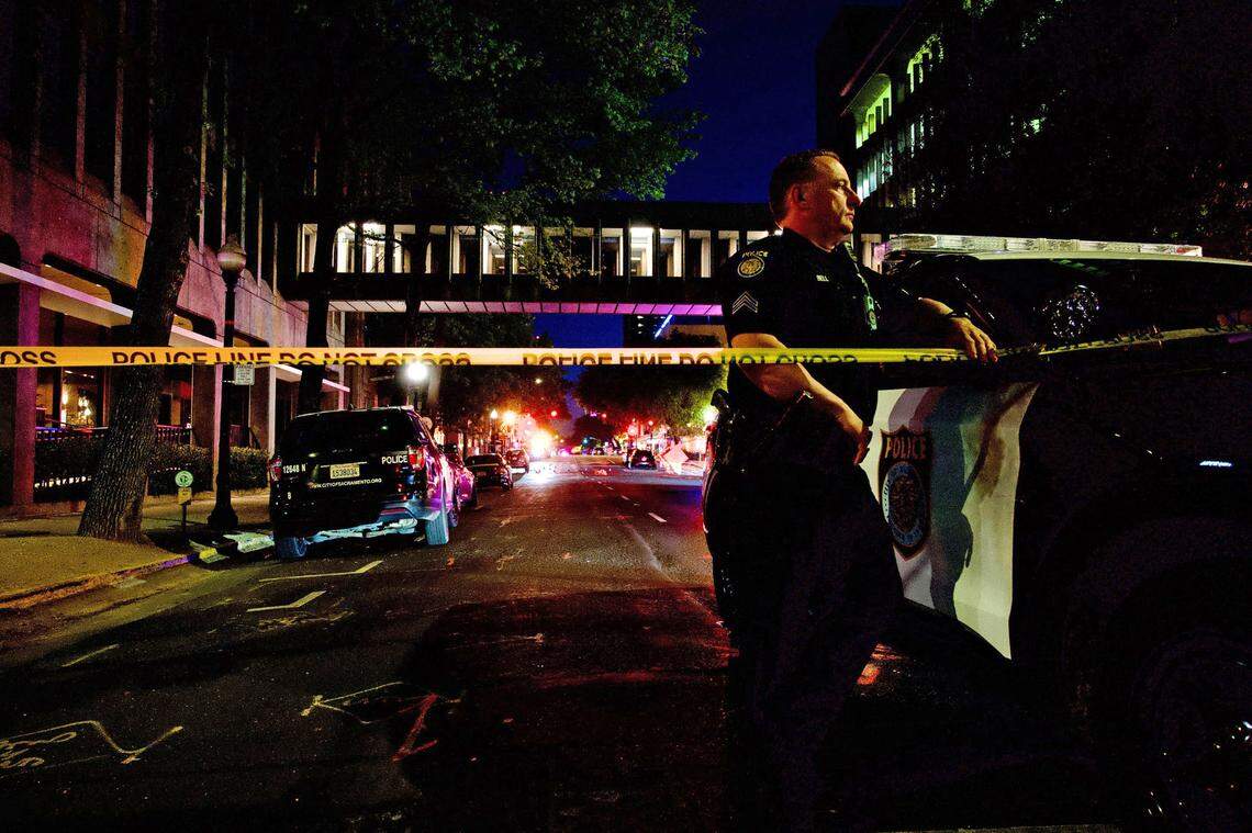 Sacramento Police officer&nbsp;David Bell stands watch at the scene of a mass shooting at 10th and L streets in downtown Sacramento on Sunday.