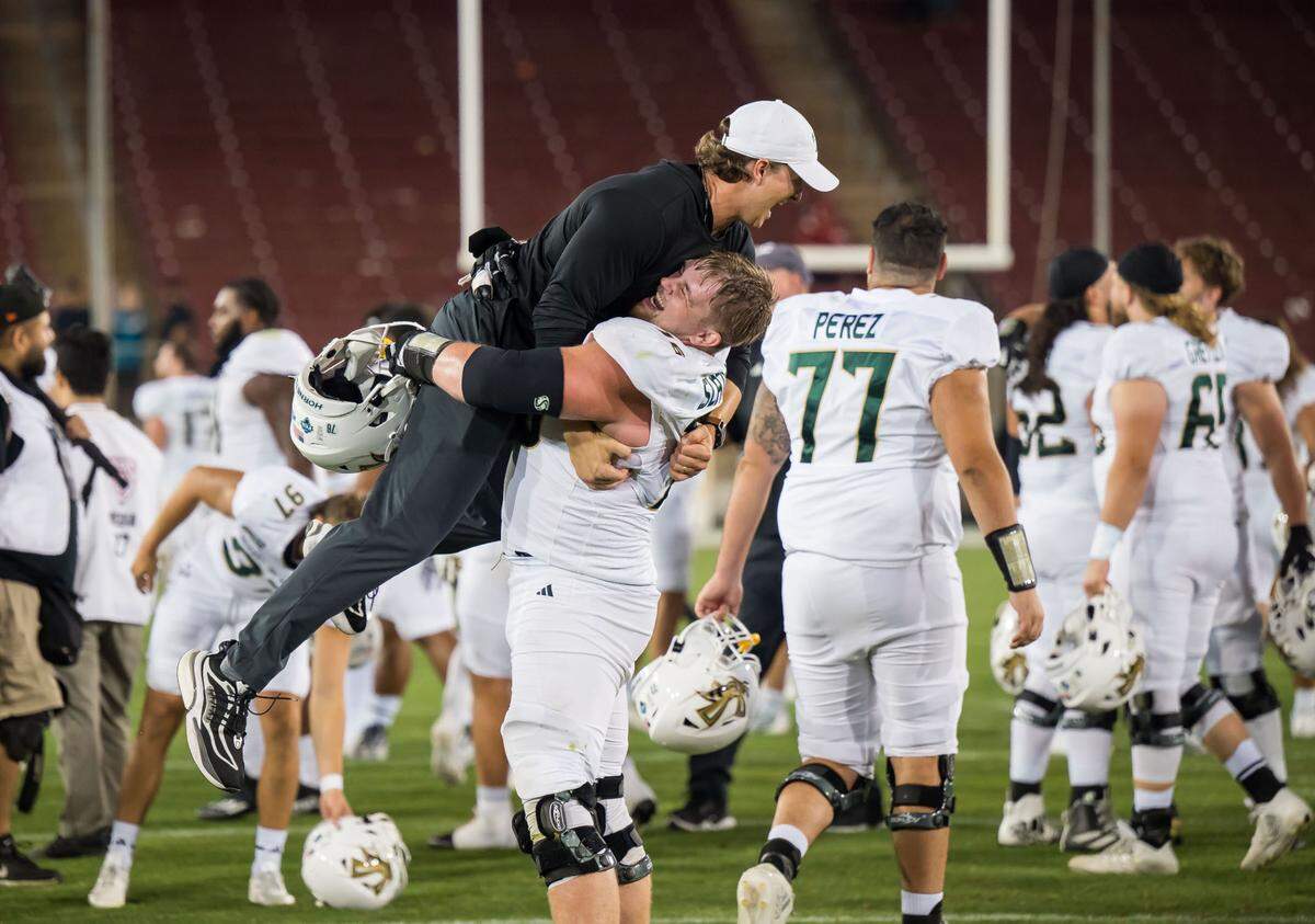 Sacramento State Hornets offensive lineman Jackson Slater (76) lifts up strength coach Nathan Morris as the team celebrates their 30-23 win over the Stanford Cardinal at the NCAA college football game Saturday, Sept. 16, 2023, at Stanford University.