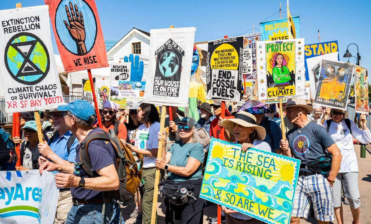 Climate change protesters march through Old Sacramento carrying signs calling for climate protection and an end to fossil fuels on Sunday.