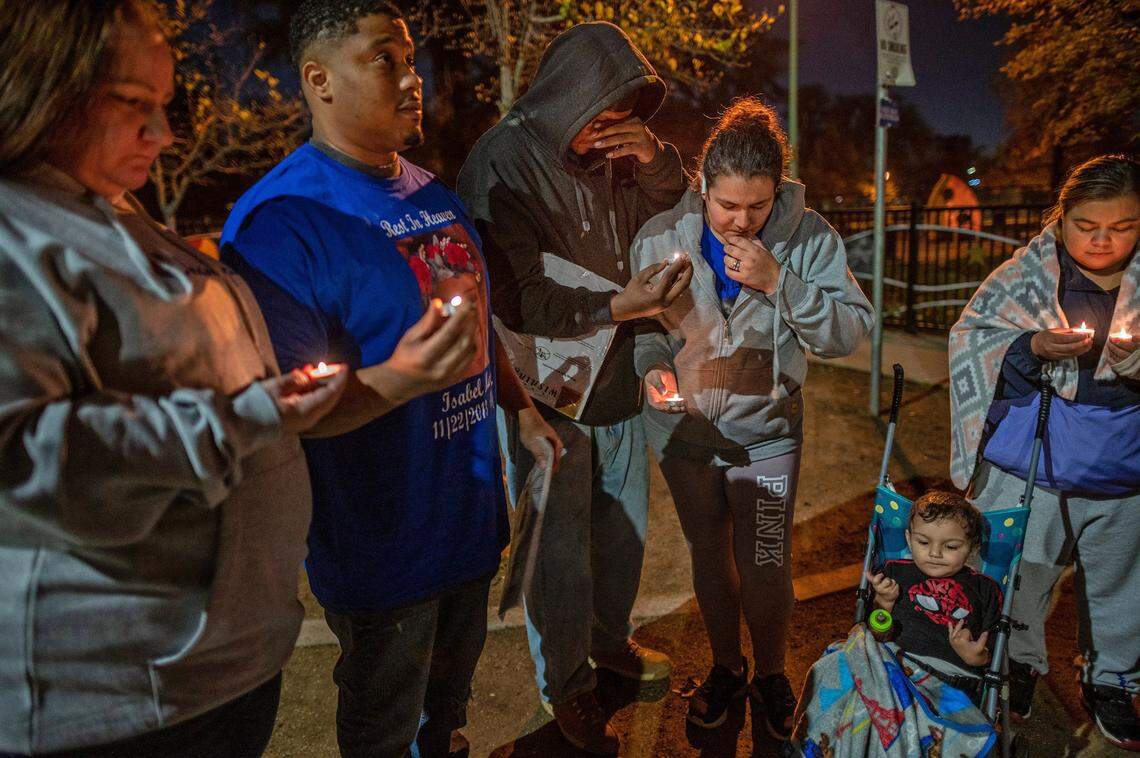 Brandon Martin, center, wipes tears as he stands with his wife Monica Delgadillo and son Brandon, 2, on Nov. 22 during a prayer vigil and celebration of life for his daughter Isabel Delgadillo Martin at Southside Park. Isabel would have turned 8 on that day, but she was killed in a Nov. 16 shooting in Upper Land Park. Family friends Tamra and Caesar Gardner, far left, and Isabel’s aunt Sonia, at right, joined the vigil.