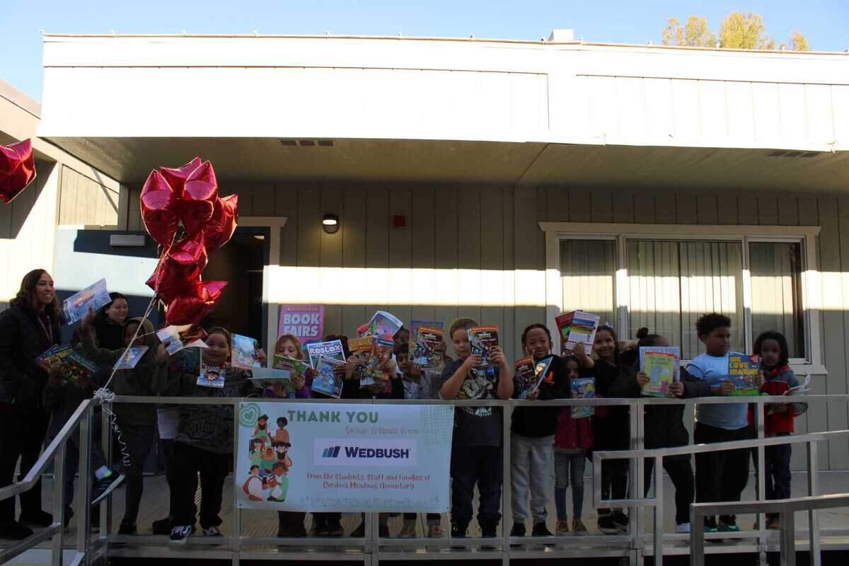 Students in Aundria Perez’s first-grade class at Cordova Meadows Elementary show off their books at the school’s first book fair in eight years on Nov. 29, 2022. Wedbush, an investment firm based in Los Angeles, partnered with Scholastic to host a Book Fair for Cordova Meadows Elementary School, a Title I School, as part of WedbushCares charity program.