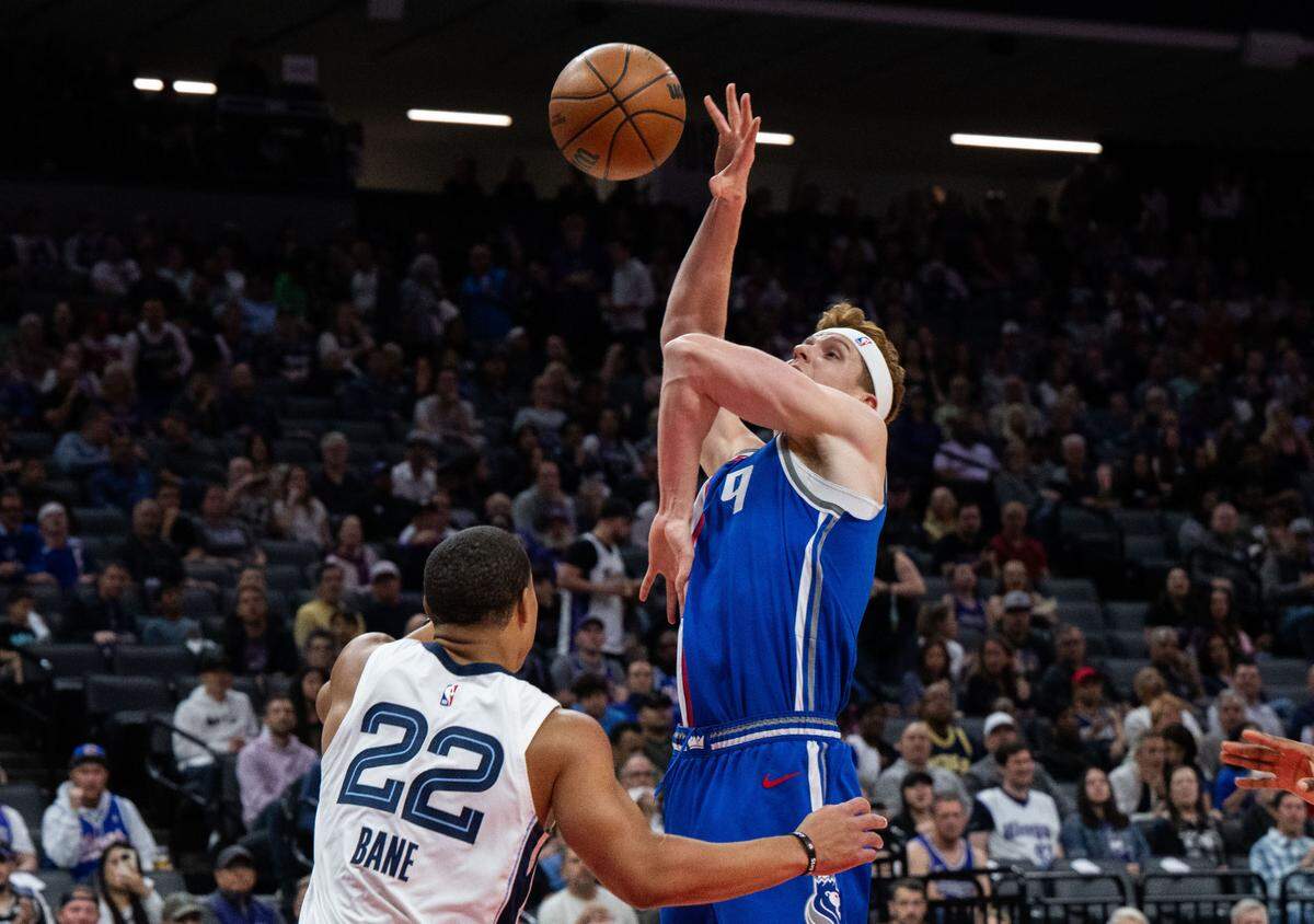 Sacramento Kings guard Kevin Huerter (9) twists his arm in an awkward position after he was fouled by Memphis Grizzlies guard Desmond Bane (22) during an NBA game on Monday, March 18, 2024 at Golden 1 Center.