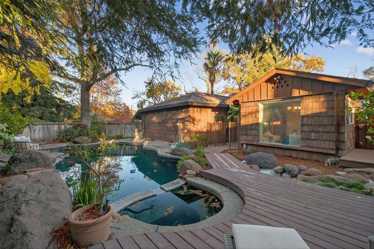 The lush backyard oasis has a pool, spa and mature shade trees.