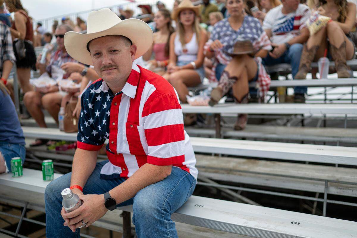 Kevin Ratliff, wearing an American flag shirt, sits in the stands before the Folsom Pro Rodeo on Thursday.