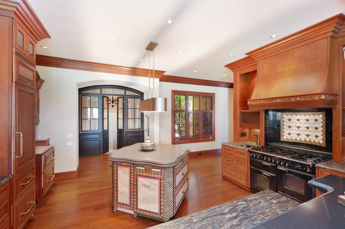 The kitchen’s main elements include the MacKenzie-Childs inspired island and a black, high-end AGA range.