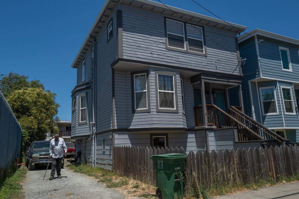 Leonard Powell walks down the driveway of his home in Berkeley in July, aided by a cane, as he suffers from two bad knees. ”It’s a cruel world and it’s not very comforting to think that you’re not the only one. People are being mistreated all over the world, but it’s personal in my case,” said Powell, whose house is under receivership.
