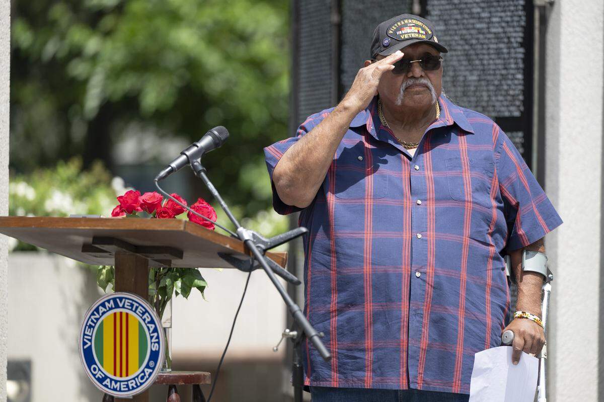 Phil Rios salutes fellow veterans during a “Reading of the Names” ceremony at the California Vietnam Veterans Memorial in Sacramento on Sunday, May 24, 2026. Rios brought 11 roses to the ceremony in honor of his 11 classmates — including Manuel Gines — that died in the Vietnam war.