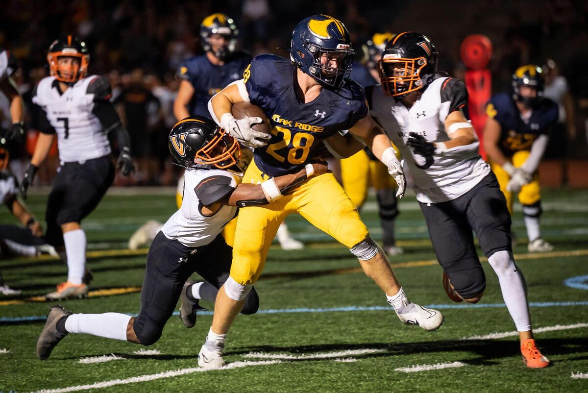 Oak Ridge Trojan running back Jake Hall (28) forces past Vacaville Bulldogs Jeffery Holden (12), left, and Brady Mott (3) to score during the second quarter at the high school varsity football game Friday at Oak Ridge High School in El Dorado Hills. Oak Ridge routed Vacaville 62-0.