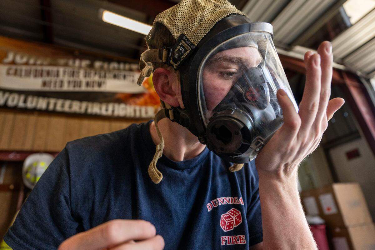 Paul Dicus, 19, a volunteer firefighter for the Dunnigan Fire Protection District, conducts a maintenance test on his self-contained breathing apparatus in May. The department faces financial struggles as they attempt to keep up with high cost of equipment.