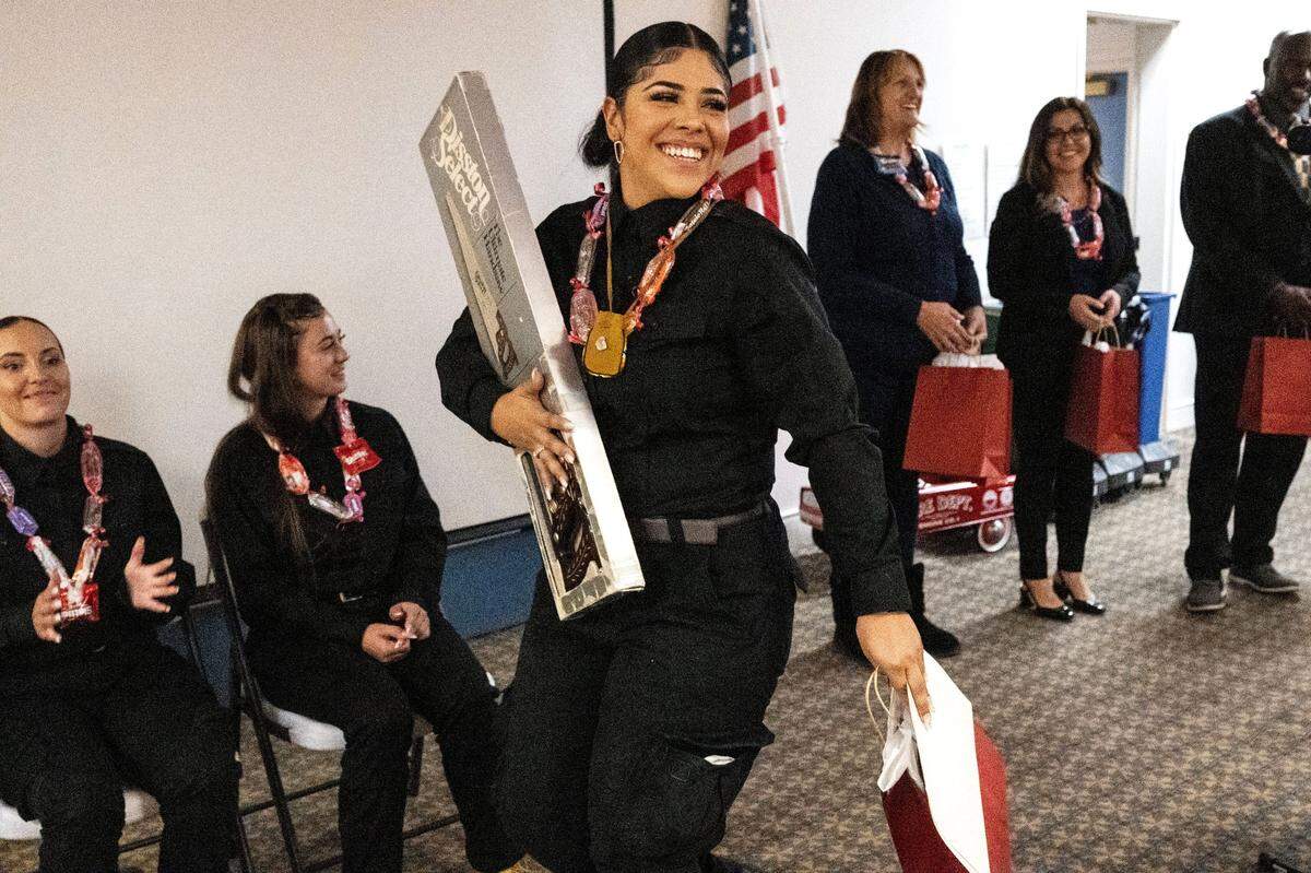 Britaney Gomez, 23, receives certificate and presents during a graduation ceremony from a first-ever program to train female inmates to become firefighters on Tuesday in Sacramento. Gomez, who was convicted of killing two people while driving under the influence of marijuana when she was 16, said she was becoming a firefighter to remember the victims.