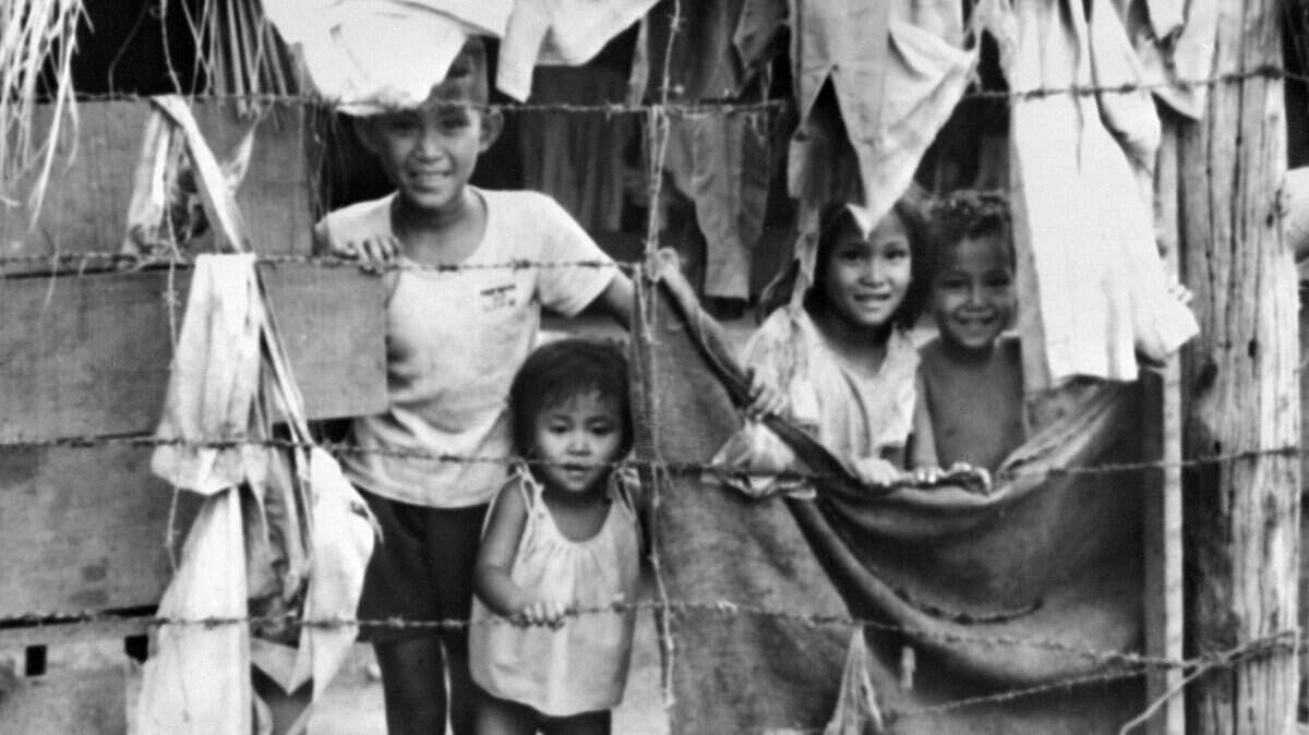 Kmer and Vietnamese refugee children stand behind barbed wires in April 1976 in Thailand. Refugees camps started in 1975 with those fleeing the Khmer Rouge, followed in 1979 by those fleeing starvation and the advancing Vietnamese army, followed by those affected by the 1984/85 Vietnamese offensive along the Thai border. 
