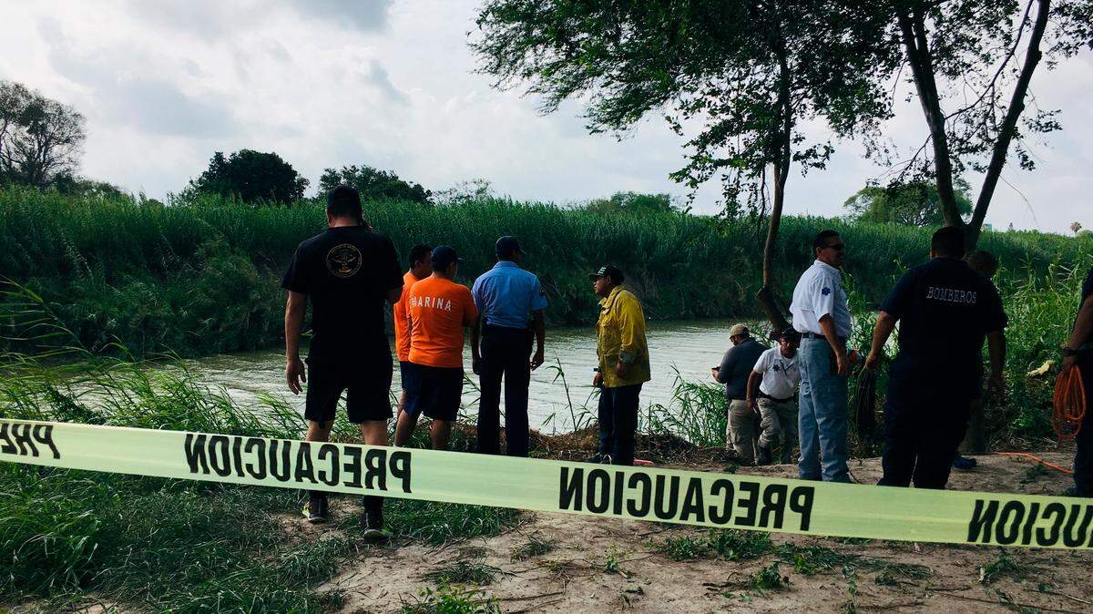 Authorities stand behind yellow warning tape along the Rio Grande bank where the bodies of Salvadoran migrant Oscar Alberto Martínez Ramírez and his nearly 2-year-old daughter Valeria were found, in Matamoros, Mexico, Monday, June 24, 2019, after they drowned trying to cross the river to Brownsville, Texas. Martinez’ wife, Tania told Mexican authorities she watched her husband and child disappear in the strong current. (AP Photo/Julia Le Duc)
