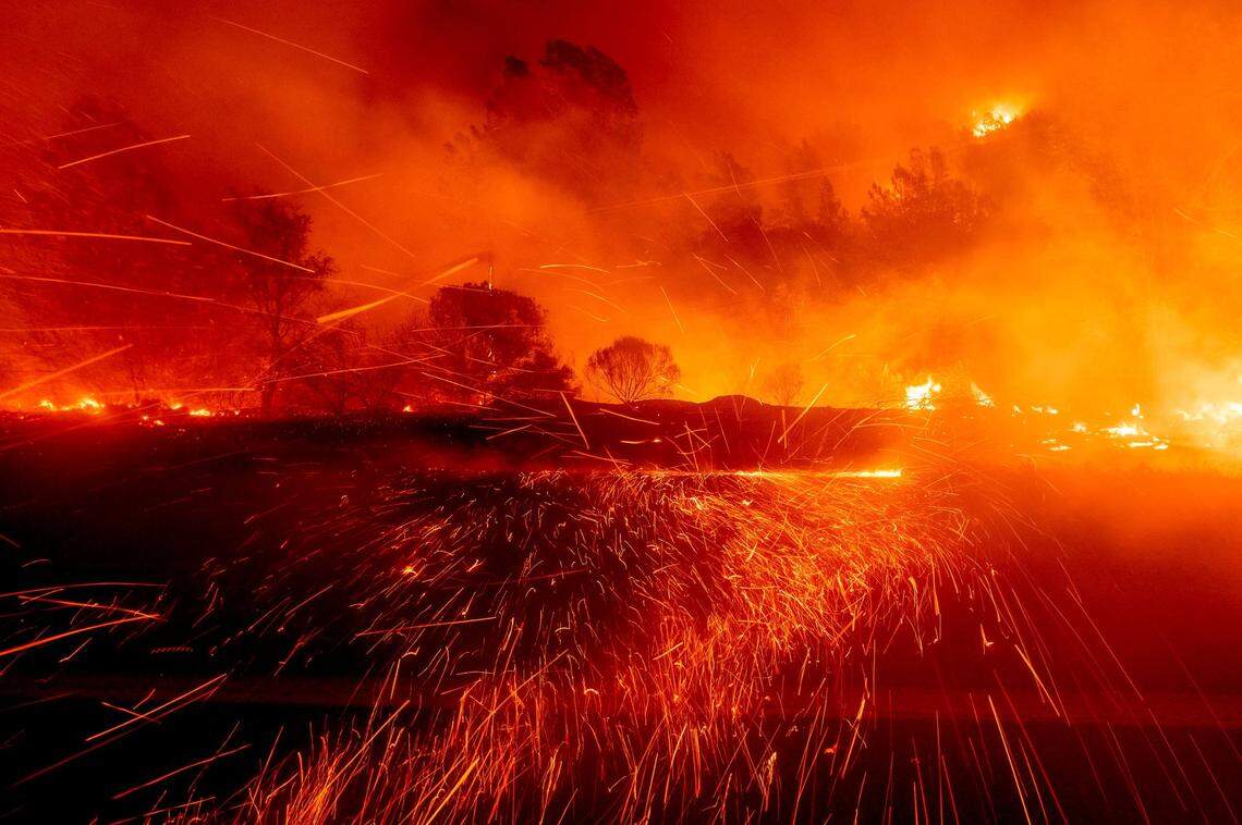 Embers fly across a roadway as the Bear Fire burns near Oroville, Calif., on Wednesday, Sept. 9, 2020. The blaze, part of the lightning-sparked North Complex, expanded at a critical rate of spread as winds buffeted the region.