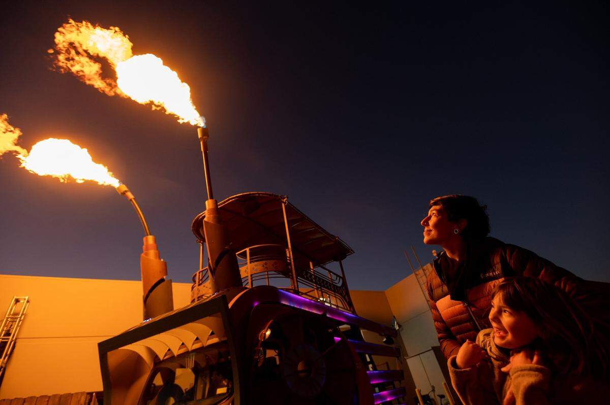 Kimberly Medici and daughter Talulah, 6, watch flames shoot Wednesday from their 18-foot-tall mobile party float named DecoFish in Diamond Springs. The float has been at Burning Man and will participate in the Mardi Gras-inspired City of Trees Parade in Sacramento on Feb. 26.