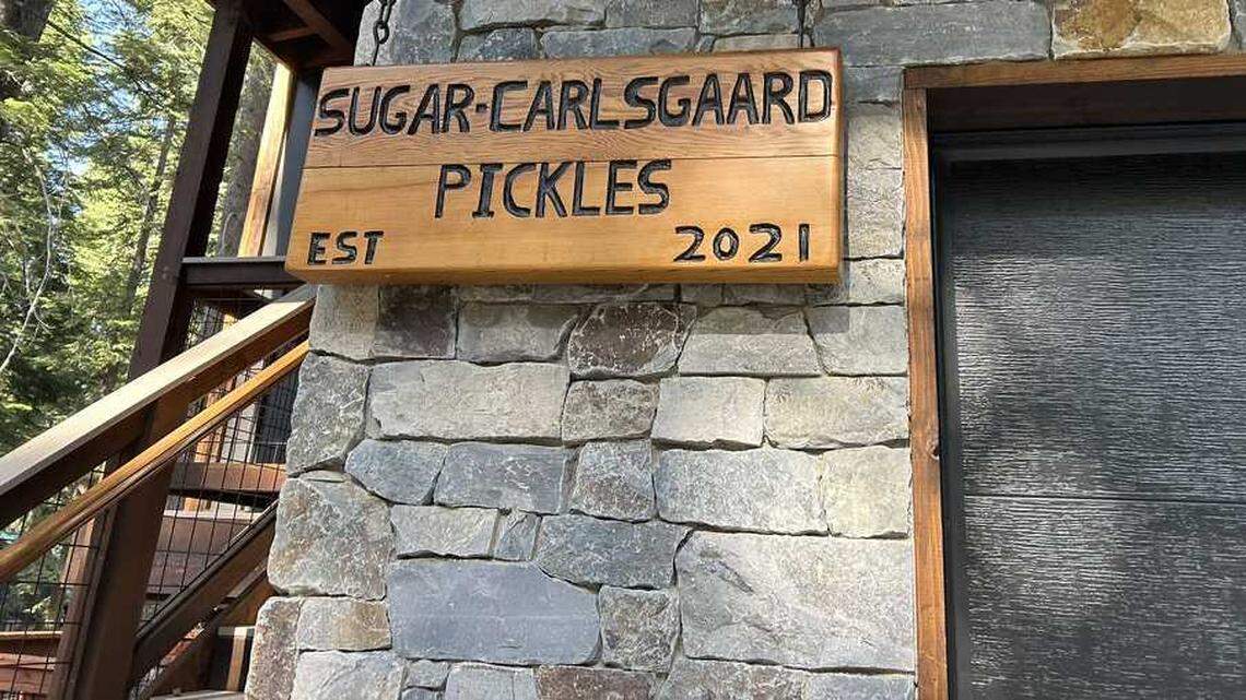 A handcarved sign outside the Tahoma home of Josh Pickles and Jordan Sugar-Carlsgaard marks the year they established their retreat near Lake Tahoe. The couple had gathered family and friends for a birthday weekend when a sudden storm capsized their boat on June 21, killing eight.