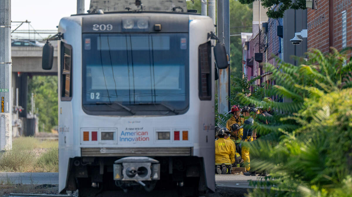 Firefighters work to extricate a man after he was struck and killed by a light rail train while riding an electric scooter in midtown Sacramento on Monday, July 21, 2025.