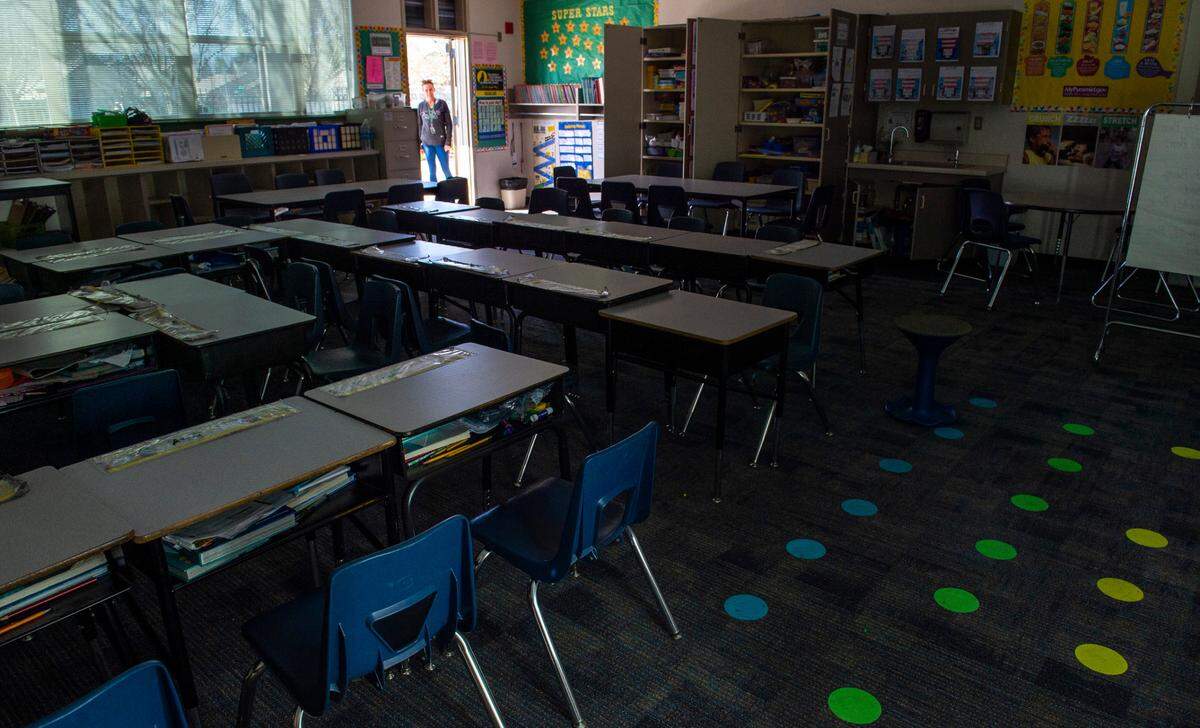 A teacher at Natomas Park Elementary School looks into an empty classroom after students had been sent home at the beginning of the coronavirus shutdown, Friday, March 13, 2020. Natomas Unified announced it will bring elementary students back on Feb. 23 as long as coronavirus infection rates remain within the state and county threshold.