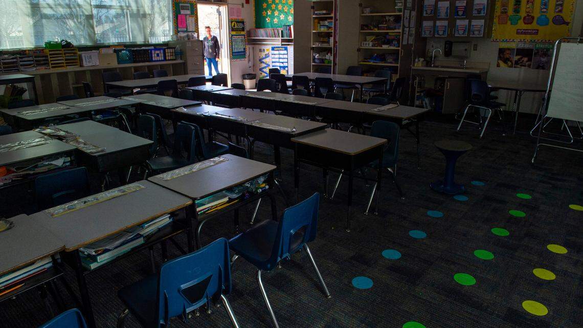 A teacher at Natomas Park Elementary School looks into an empty classroom on Friday, March 13, 2020.