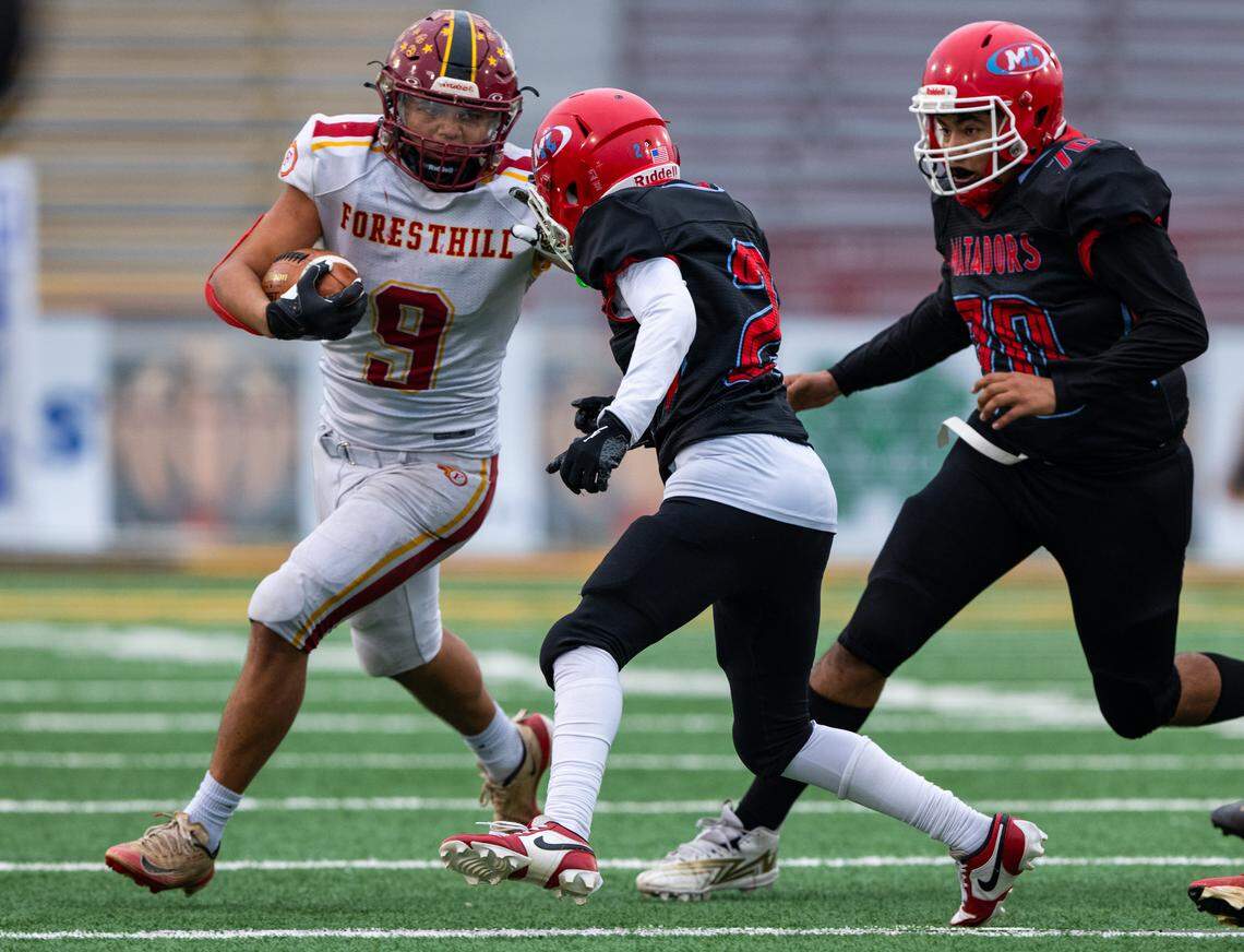 Foresthill Wildfires running back Vincent Navarro (9) is tackled by Mira Loma Matadors defensive back Ceasar Diaz (2) after a short gain in the CIF Sac-Joaquin Section Division VIII championship at Hughes Stadium in Sacramento on Saturday.