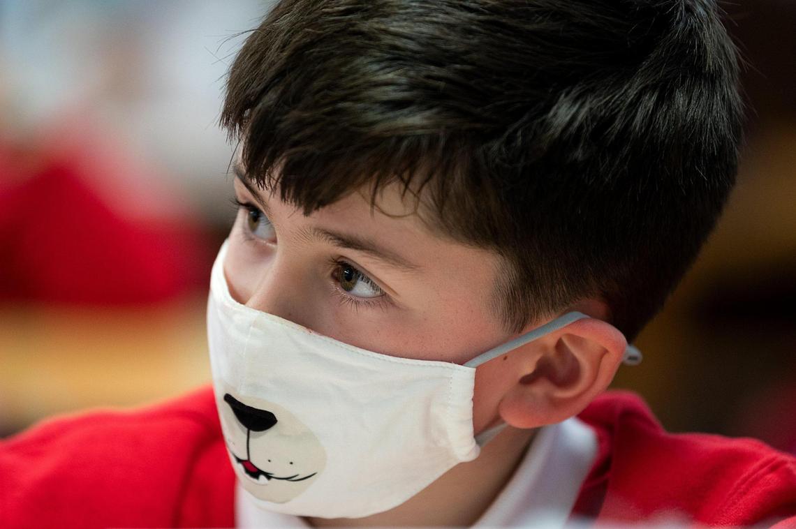 Joseph Markstein, 7, wears a face mask during his first grade class at Saint Philomene School on Wednesday, Feb. 10, 2021, in Sacramento. All the student are required to wear a face covering while on campus and have their temperature taken when they arrive at school in the morning.