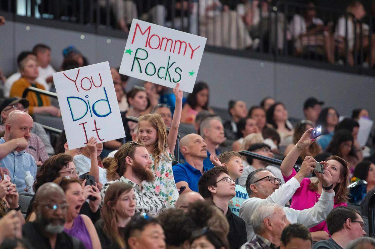 Vivian Yelchaninova, 9, holds a sign for her mother during the Sacramento State College of Business commencement on Friday.