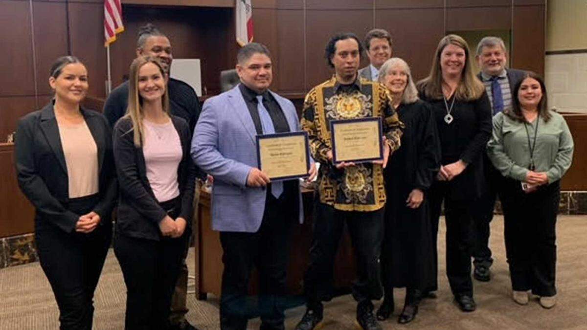 Adrian Rodriguez, center left, and Joseph Rodriguez, center right, celebrate being the first two graduates of a Yolo County diversion program on Wednesday, March 15, 2023, in Woodland. Plans are to enroll as many as 40 people in the year-long program, which is a partnership between the District Attorney’s Office, the county Public Defender’s Office, the court and others in the community.