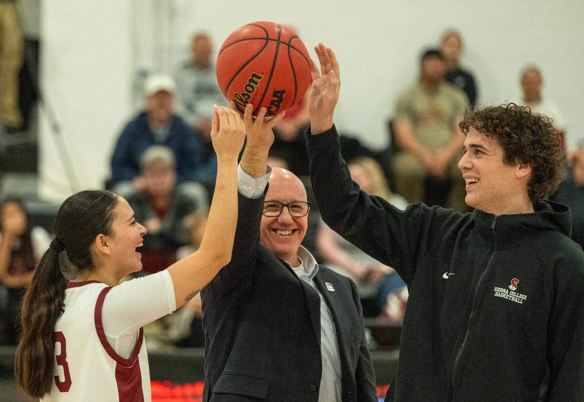 Sierra College president Willy Duncan holds up a basketball for a ceremonial tip-off before the inaugural athletic contests at the Rocklin campus’ new gymnasium Tuesday. Juliana Chavez (3) represents the women’s team, while Mitch Hauxwell Te-Paa represents the men’s team.