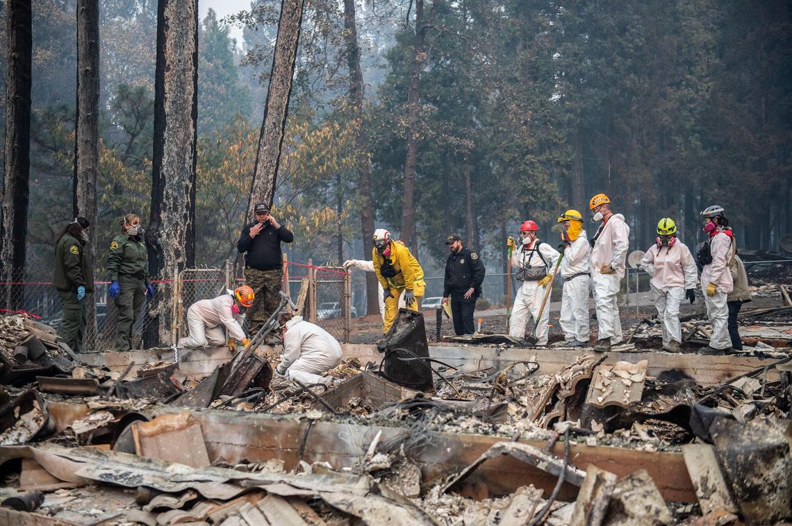An El Dorado County search and rescue team look for  remains of a body on West Park Drive in Magalia, Thursday, Nov. 15, 2018 after the Camp Fire burned many of the homes in the area.