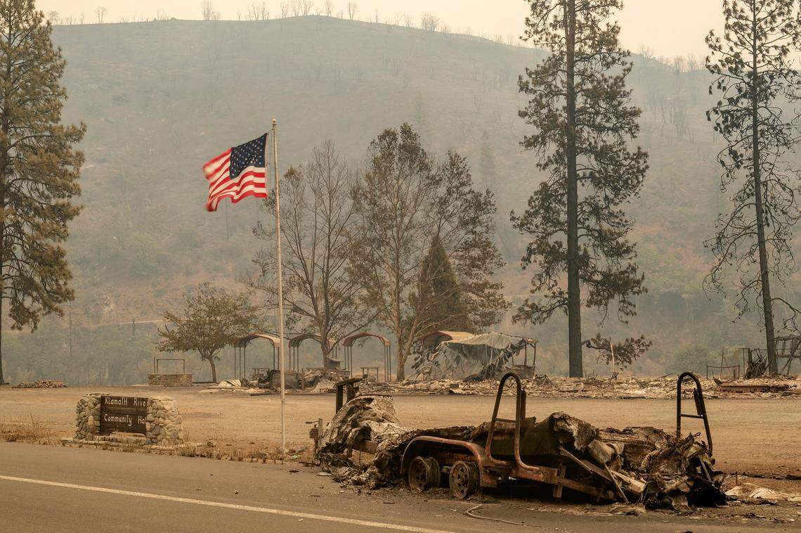 The American flag waves in the wind in front of what used to be the Klamath River Community Hall along Highway 96 as the McKinney Fire burns in Klamath National Forest in Siskiyou County on Sunday.