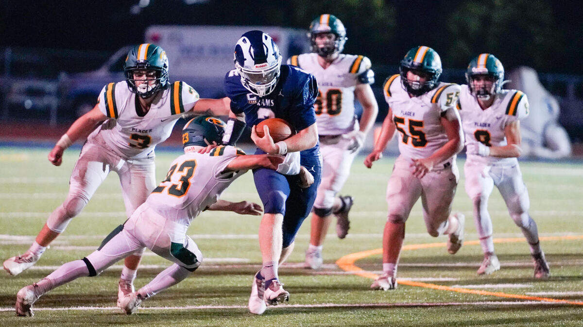 Casa Roble quarterback Jason Lindahl (2) runs past a group of Placer defenders in his team’s 40-33 win.