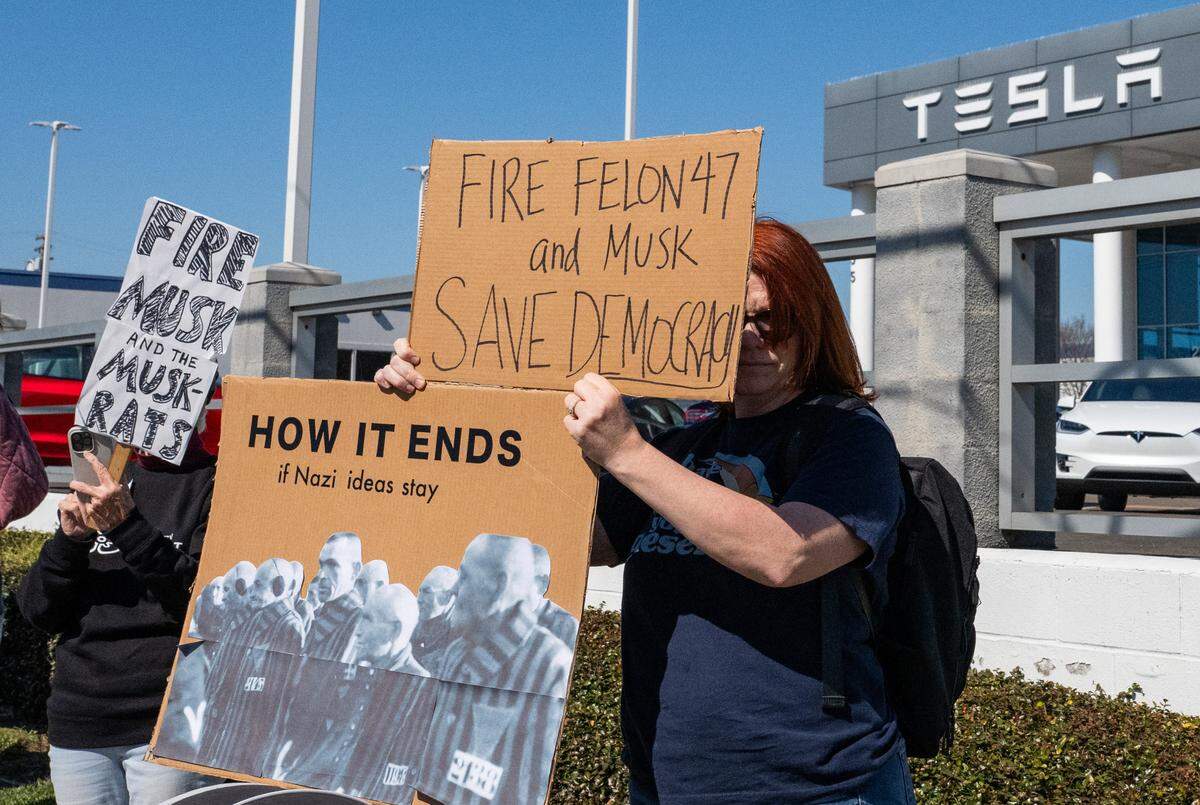 Demonstrators rally against Elon Musk at a Tesla dealership on Arden Way near Sacramento on Saturday, March 8, 2025. More than 100 people lined both sides of street to protest the role of the tech billionaire and Tesla CEO in the Trump administration.