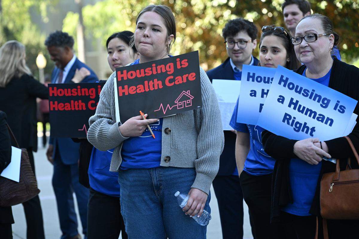 Allison Gross, center, with The People Concerned Los Angeles, listens to speakers at a rally about funding for the state’s homelessness crisis on Tuesday at the state Capitol.