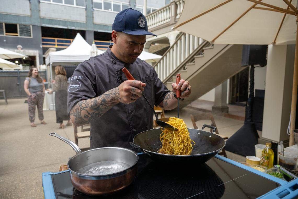 Chef Tu David Phu, an Oakland-born Vietnamese American who was featured on season 15 of the Bravo Network’s “Top Chef,” cooks a noodle dish on an induction stove during a demonstration at the Leland Stanford Mansion in downtown Sacramento in June.