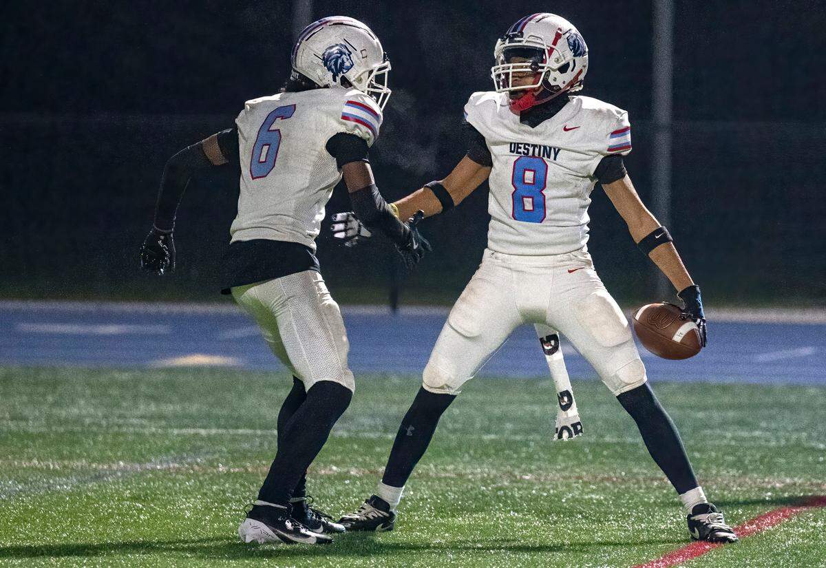 Destiny Christian Lions receiver Nehemiah Simmons (8) celebrates a 48-yard catch and run touchdown with Antonio Johnson (6) against Christian Brothers in a Sac-Joaquin Section Division III quarterfinal game on Friday, Nov. 15, 2024, in Sacramento.