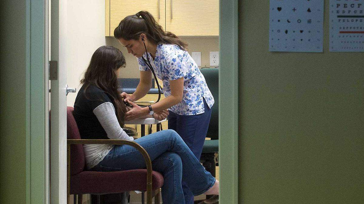 A medical assistant examines a patient in Weimar, Calif., in 2015. After the Department of Health Care Services canceled Medi-Cal contract awards under pressure from major insurers, some consumer advocates question the administration’s willpower to improve care in the safety-net program.