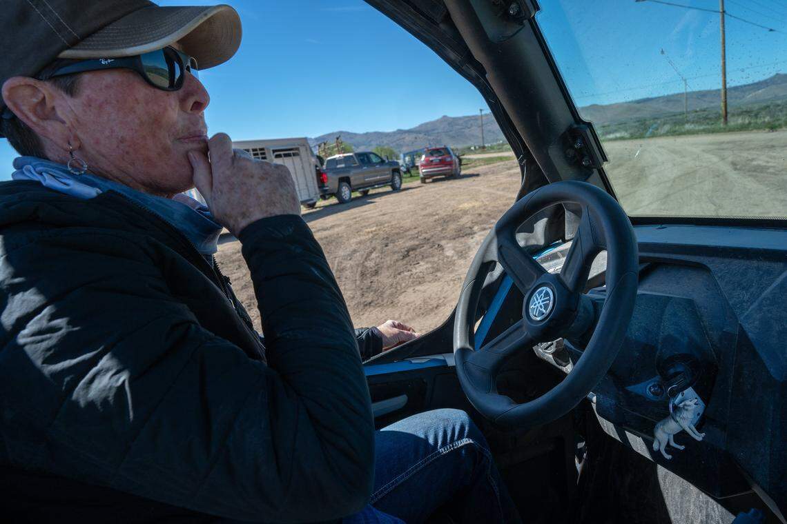 Deena Edmonston sits in her side-by-side vehicle as she prepares to search for wolves at DS Ranches in Sierra Valley in May. Despite her deep concern over several calves that have been killed by wolves, she maintains a sense of humor— even keeping a wolf keychain as a reminder of the irony. 