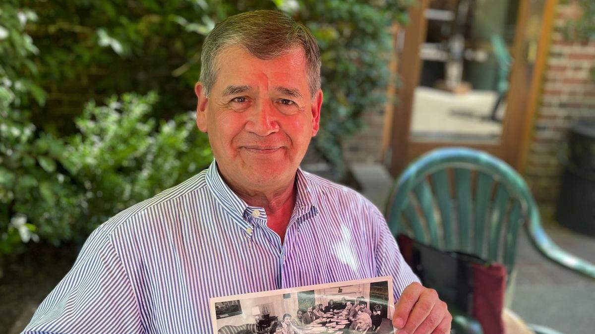 George Raya, 73, sits at the Old Soul at The Weatherstone cafe in Sacramento on June 9 and holds a 1977 photo of himself and other participants in the National Gay Task Force at the White House. 