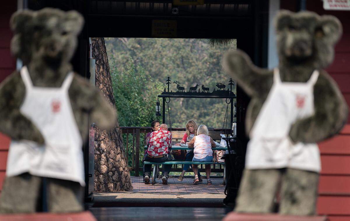 Cindy Trimm, with fiends Blaine and Julie Campbell and Kathy Drobnik, have a meal at Abel’s Apple Acres, a member of the Apple Hill Growers Association in El Dorado County in September as the Caldor Fire smolders further up Highway 50.
