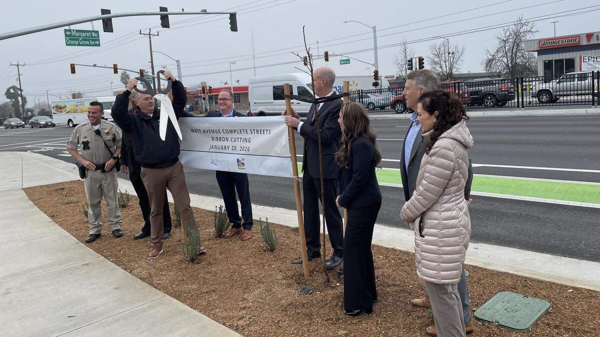Sacramento County Supervisor Rich Desmond raises a giant pair of scissors at a ribbon cutting ceremony with other local officials Tuesday, Jan. 20, 2026, to celebrate an project that repaved and improved a North Highlands section of Watt Avenue between Interstate 80 and Roseville Road.