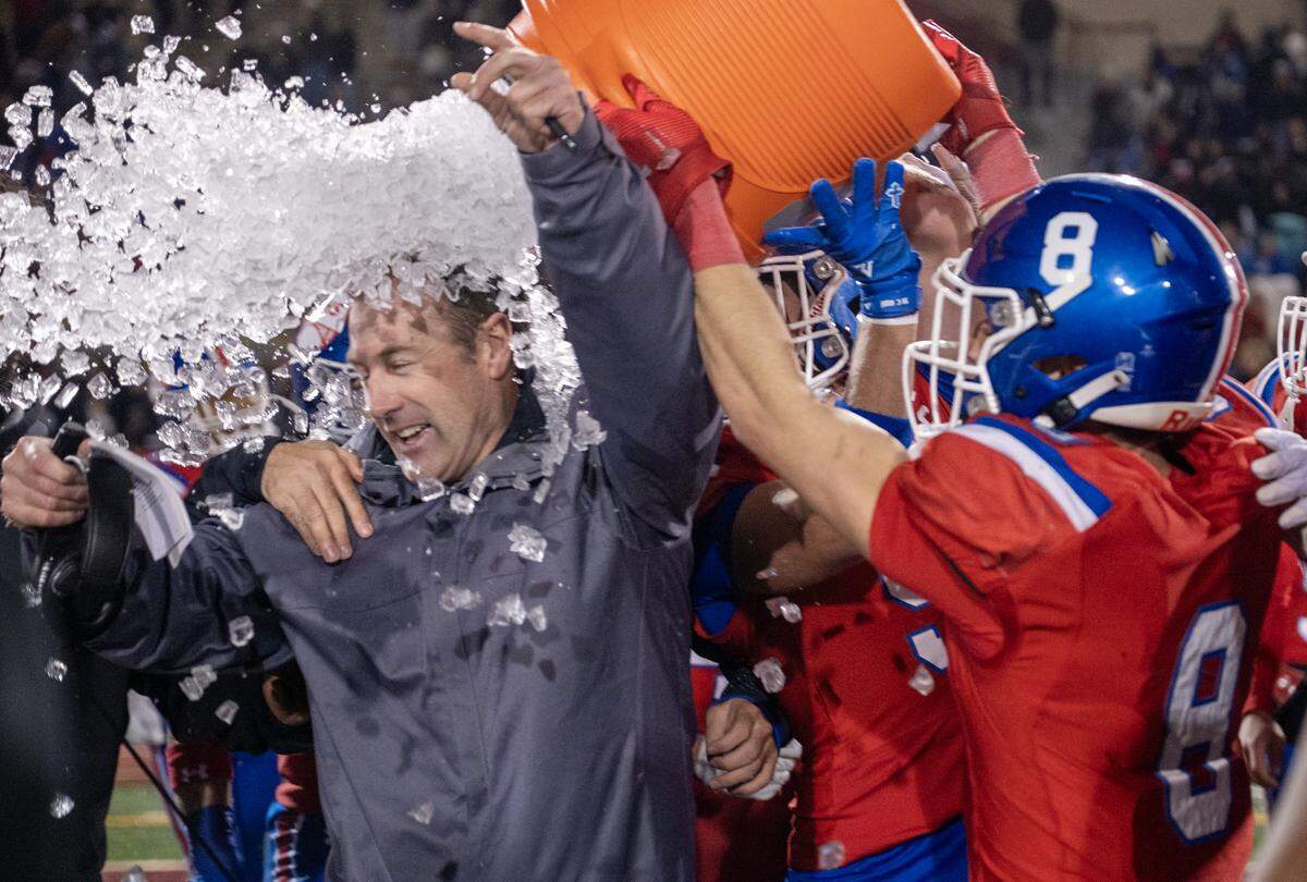 The Folsom Bulldogs coach Paul Doherty is doused with water and ice by Dylan Wolfe (8) following the Bulldogs 21-14 victory over the Oak Ridge Trojans in the CIF Sac-Joaquin Section football Division l championship on Friday, Nov. 28, 2025, at Hughes Stadium in Sacramento.