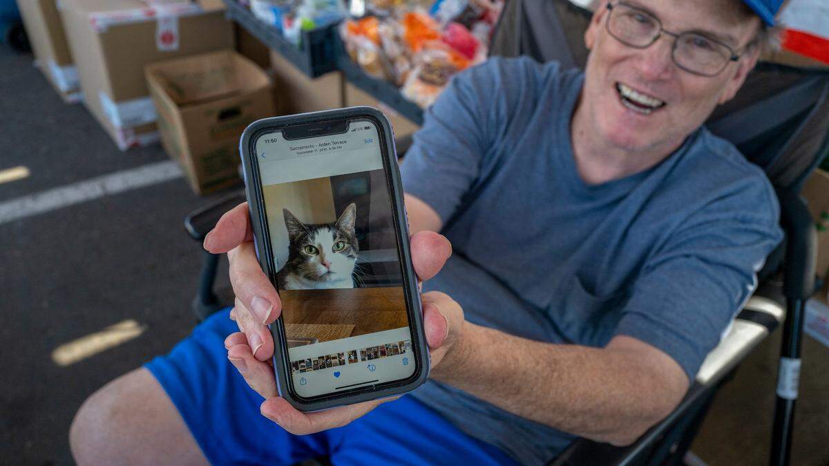 Warren Thompson shows a picture of the cat who kept him company during his four-hour drive escaping the Camp Fire in 2018. Thompson, who lost everything when the town of Paradise burned and now lives in Sacramento, was volunteering at an evacuation center in Rocklin for the Mosquito Fire in September 2022. “I’ve been through this myself before so it would be good to come out and help as much as possible,” he said.